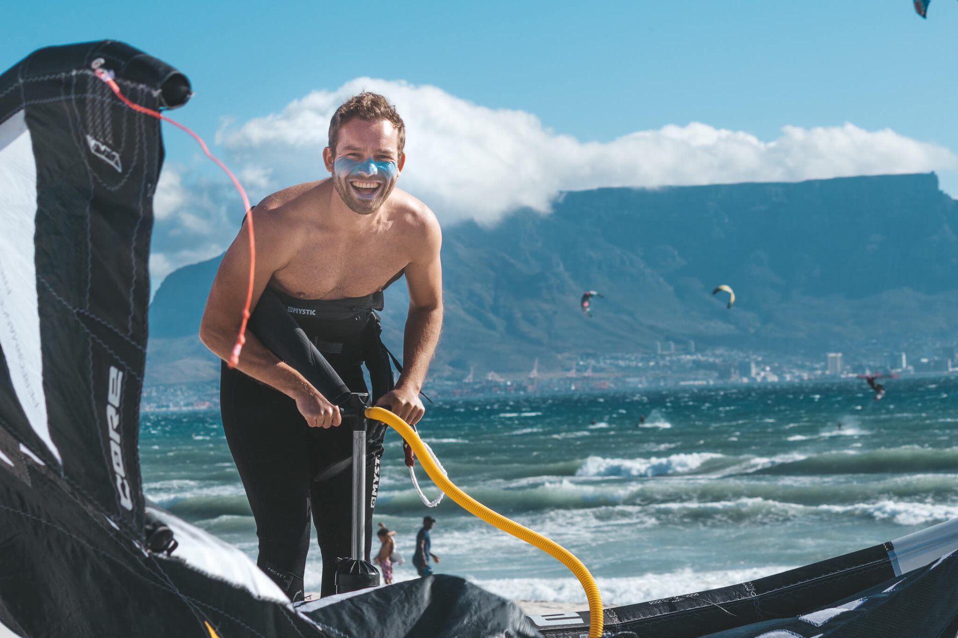 Kitesurfer mit Equipment am Strand - bereit für die nächste Session